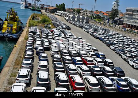 Molo commerciale con automobili importate (VW T-Roc) e pale per turbine eoliche sul molo di Porto, Portogallo Foto Stock