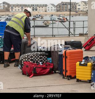 Hugh Town, St Marys, Isles of Scilly, Regno Unito. 10 giugno 2023. I bagagli dei passeggeri del traghetto vengono smistati sulla banchina di Hugh Town, affacciata sulla Town Beach, St Foto Stock