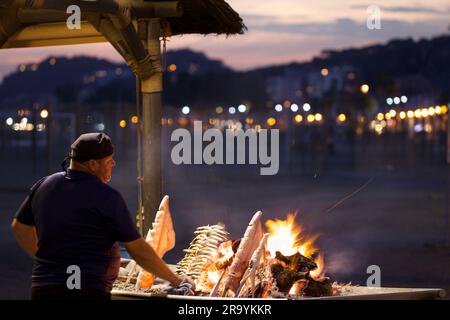 Chiringuito tradizionale spagnolo, cucina di sardine fresche, pesce e calamari in piccole capanne sulla spiaggia Foto Stock