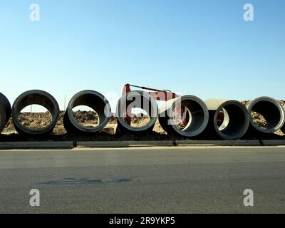 Cairo, Egitto, 24 giugno 2023: Un escavatore di scavo per la preparazione di grandi parti di tubi dell'acqua in loco, tubi di sanificazione, miglioramento dell'infrastruttura a Foto Stock