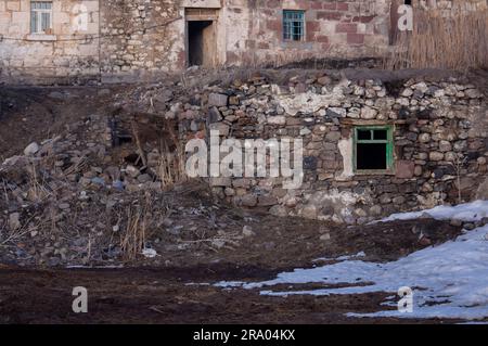 Vista frontale di vecchie case in pietra in un villaggio abbandonato. Türkiye - tradizionale casa in pietra nella città di Ardahan Foto Stock