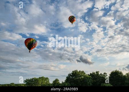 Due mongolfiere sorvolano Middletown, N.Y., dopo il decollo dall'aeroporto di Randall il 10 luglio 2021. Foto Stock
