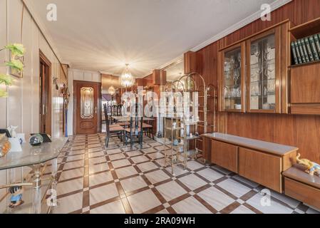 soggiorno eccessivamente decorato e decorato in modo luminoso con una parete ricoperta di pannelli di legno scuro e molti specchi Foto Stock