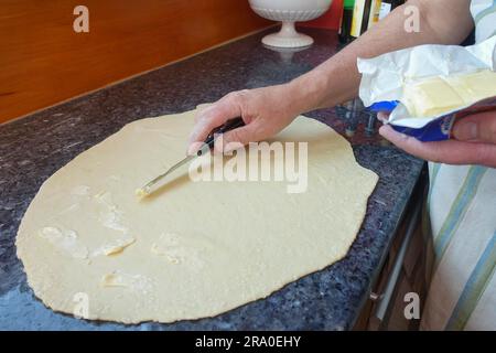 Cucina sveva, Kraepfle della Svevia superiore con Gsaelz, pasticceria dolce, preparazione di ciambelle ripiene con marmellata, spalmare l'impasto ondulato con burro Foto Stock