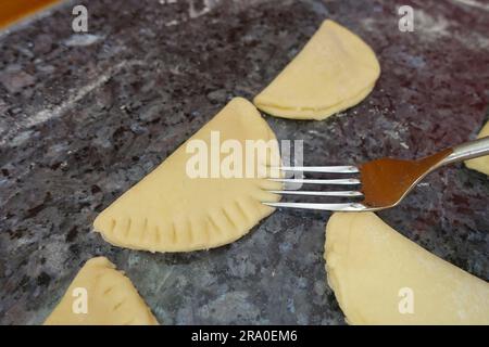 Cucina sveva, Kraepfle della Svevia superiore con Gsaelz, pasticceria dolce, preparazione di ciambelle ripiene con marmellata, spremere i pezzi di pasta con la forchetta Foto Stock