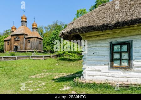 Un tipico ucraino antica chiesa ortodossa, con una casa di dettaglio in primo piano in Pirogovo vicino a Kiev Foto Stock