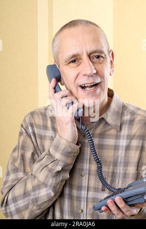 Bel uomo parlando delicatamente con un amico al telefono Foto Stock