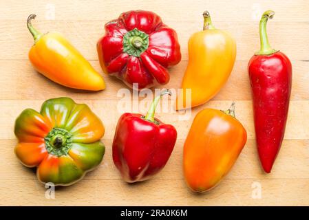 Un gruppo di peperoni gialli, arancioni e verdi naturali del giardino Foto Stock