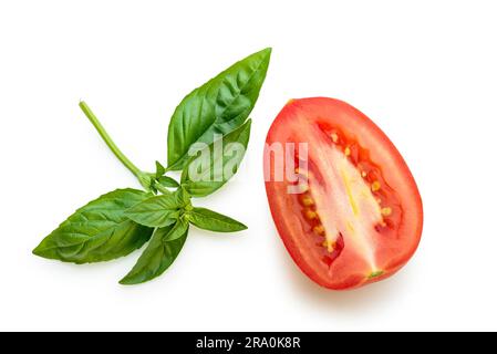 Foglie di basilico tagliato e pomodoro di San Marzano isolati su sfondo bianco Foto Stock