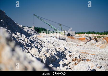 L'escavatore a piedi opera vicino a pali in una fossa mineraria Foto Stock