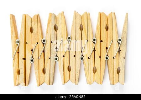 Nove clothespins in legno in fila, su sfondo bianco Foto Stock