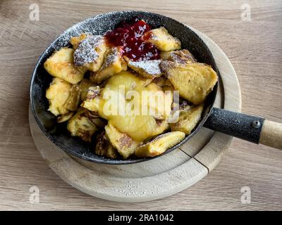 Padella in ghisa con manico con piatto classico della cucina alpina Kaiserschmarrn cosparso di zucchero a velo, Austria Foto Stock