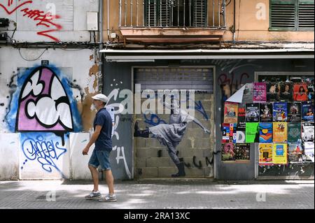 Passanti di fronte al muro di una casa con uno stencil, Palma di Maiorca, Spagna Foto Stock