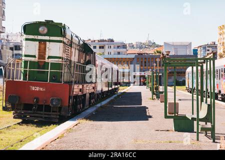 Locomotive diesel e vecchie carrozze coperte di graffiti aspettano di partire alla stazione ferroviaria di Durrës, sulla costa albanese Foto Stock