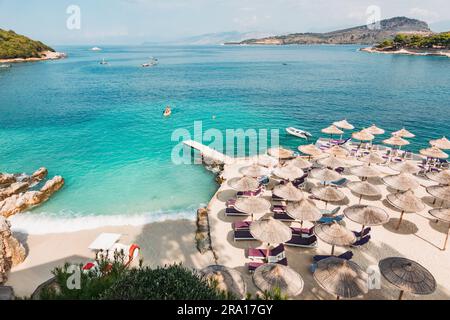 Lettini, ombrelloni e acque turchesi che aspettano i turisti a Rilinda Beach, Ksamil, Albania Foto Stock