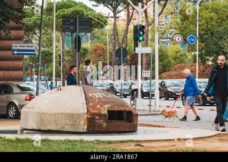 I pedoni attraversano un bunker di cemento a Tirana, uno dei 173.000 costruiti in tutto il paese dal 1967 al 86, durante il regime di Enver Hoxha Foto Stock