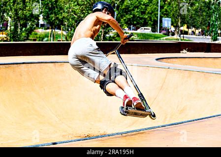 Giovane che pratica lo Scootering (Freestyle Scootering) nel nuovo Skatepark del parco centrale di Igualada, Barcellona, Spagna Foto Stock