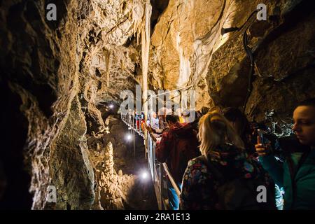 I turisti camminano nelle grotte Punkva (Punkevni) decorate con stalattiti e stalagmiti nel Carso Moravo, Repubblica Ceca, 29 giugno 2023. (Foto CTK/Patrik Uhlir) Foto Stock