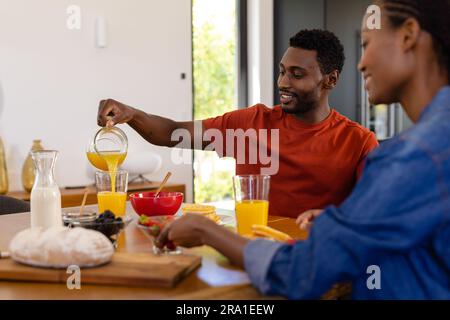 Felice coppia afro-americana che gusta la colazione nella sala da pranzo Foto Stock