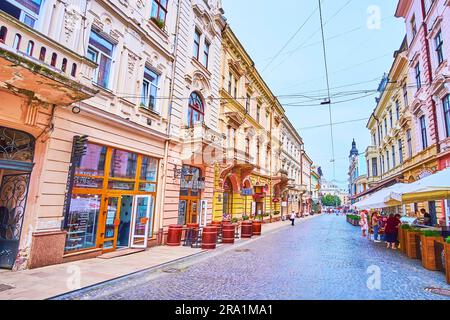 CHERNIVTSI, UCRAINA - 16 LUGLIO 2021: Bar, caffetterie e ristoranti in via Olha Kobylyanska con bellissime case a schiera e palazzi d'epoca Foto Stock