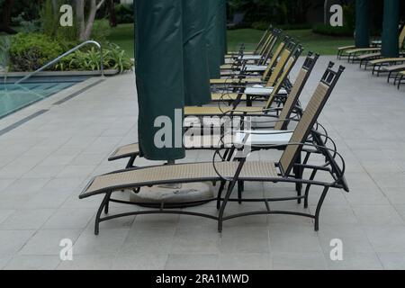 Fila di sedie a sdraio nella piscina dell'hotel, sdraio per le vacanze, Mkhuse, Sud Africa, concetto di vacanza, oggetti, allestimento, mobili da esterno Foto Stock