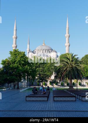 I turisti seduti sulle panchine nei giardini di fronte alla Moschea Sulatn Ahmed, detta anche Moschea Blu, quartiere Sultanahmet, Istanbul, Turchia Foto Stock