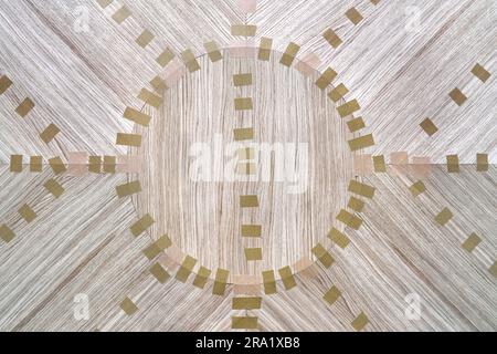 Impiallacciatura articolata con nastro in tela per il piano del tavolo da pranzo con motivo geometrico sul banco di lavoro nella vista ravvicinata superiore dell'officina Foto Stock