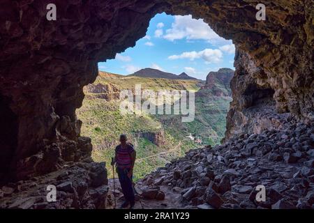 Escursionista nella grotta della Fortezza di la Fortaleza nel Barranco de Tirajana, Isole Canarie, Gran Canaria Foto Stock