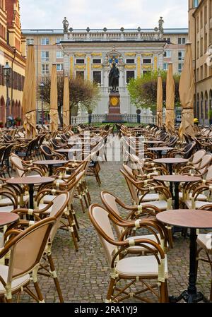 Sedie e tavoli vuoti sul Naschmarkt la mattina presto, il monumento di Goethe e alte Boerse sullo sfondo, Germania, Sassonia, Lipsia Foto Stock