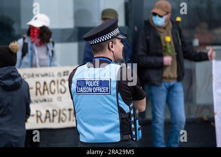 Un ufficiale di polizia del Devon e della Cornovaglia in servizio mentre i manifestanti si riuniscono fuori dall'hotel di Beresford a sostegno dei richiedenti asilo a Newquay in Cornovaglia nel Th Foto Stock