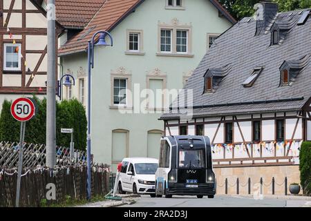 30 giugno 2023, Sassonia, Gelenau: Una navetta automatizzata attraversa la città di Erzgebirge come parte di una fase di prova. La Chemnitz University of Technology, la Ingenieurgesellschaft Auto und Verkehr (IAV), il German Aerospace Center (DLR) e i comuni di Zwönitz e Gelenau stanno testando una navetta a guida autonoma per acquisire esperienza iniziale sull'uso di tali veicoli nella regione rurale di bassa montagna. Il veicolo sarà utilizzato nel comune di Gelenau tra il 30 giugno e il 6 luglio 2023. Gli interessati di età legale possono testare la navetta gratuitamente e condividere la Foto Stock