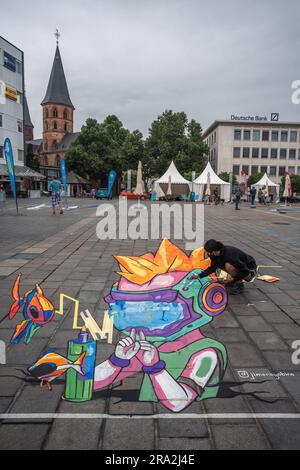 Kaiserslautern, Germania. 30 giugno 2023. L'artista messicana Jimena Gabino completa il suo dipinto 3D. Undici artisti internazionali provenienti da 6 paesi hanno trasformato la pavimentazione Stiftsplatz (piazza) in arte tridimensionale, con "digitalizzazione e Smart City" come argomento di quest'anno. La Street art 3D utilizza la prospettiva per creare illusioni ottiche dello spazio. I visitatori erano invitati a guardare tutti gli artisti al lavoro per tre giorni. Questo è il terzo e ultimo giorno dell'evento. Credito: Gustav Zygmund/Alamy News Foto Stock