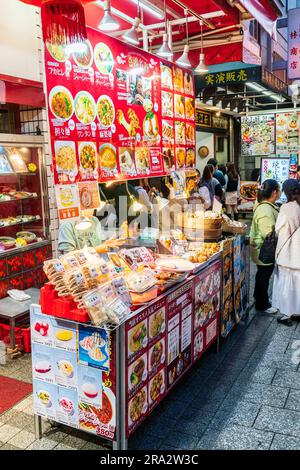 Bancarelle di cibo da asporto cinese di notte a Nankinmachi, Chinatown, Kobe. Il banco vende panini cotti al vapore e gyoza, i panini cotti in contenitori di bambù. Foto Stock