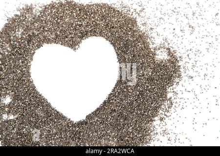 Semi di chia della pianta Salvia hispanica. Cibo funzionale molto sano da utilizzare in varie ricette. Forma del cuore realizzata con l'immagine concettuale dei semi. Foto Stock