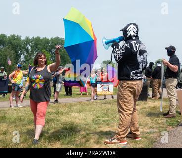 HUDSON, WISCONSIN, USA - 17 GIUGNO 2023: Manifestanti anti anti LGBTQ+ non identificati mascherati e partecipanti al festival alla celebrazione dell'Hudson Pride. Foto Stock