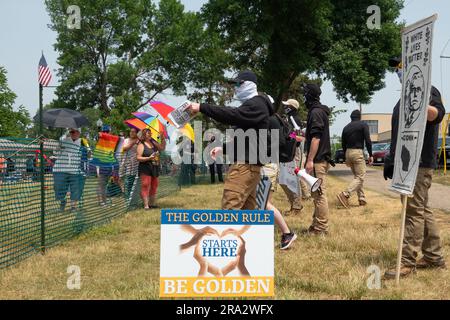 HUDSON, WISCONSIN, USA - 17 GIUGNO 2023: Manifestanti anti anti LGBTQ+ non identificati mascherati e partecipanti al festival alla celebrazione dell'Hudson Pride. Foto Stock