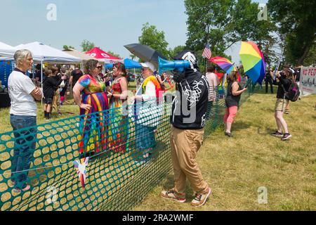 HUDSON, WISCONSIN, USA - 17 GIUGNO 2023: Manifestanti anti anti LGBTQ+ non identificati mascherati e partecipanti al festival alla celebrazione dell'Hudson Pride. Foto Stock