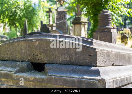 Una lapide con un angolo spezzato che rivela un condotto d'aria dietro di essa si trova nel camposanto barocco del cimitero di Elias a Dresda, Sassonia, Germania – una scorta di lapidi che abbraccia due secoli. Realizzato nel 1680 come cimitero della peste, il cimitero di Elias fu notevolmente ampliato e murato durante il 1724 sotto la guida dei maestri costruttori George Bähr, architetto della Frauenkirche di Dresda, e Johann Gottfried Fehre, che aggiunse 41 case a cripta voltate (Grufthäuser) con fronti ad arco lungo le mura ovest e nord – un'innovazione architettonica per Dresda a quel tempo. L'ultima sepoltura avvenne il 21 Ju Foto Stock