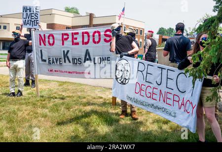 HUDSON, WISCONSIN, USA - 17 GIUGNO 2023: Manifestanti anti anti LGBTQ+ non identificati mascherati e partecipanti al festival alla celebrazione dell'Hudson Pride. Foto Stock