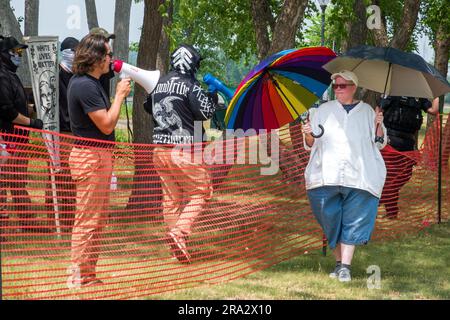 HUDSON, WISCONSIN, USA - 17 GIUGNO 2023: Manifestanti anti anti LGBTQ+ non identificati mascherati e partecipanti al festival alla celebrazione dell'Hudson Pride. Foto Stock