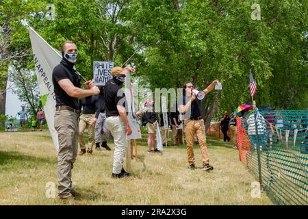 HUDSON, WISCONSIN, USA - 17 GIUGNO 2023: Manifestanti anti anti LGBTQ+ non identificati mascherati e partecipanti al festival alla celebrazione dell'Hudson Pride. Foto Stock