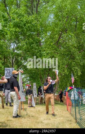 HUDSON, WISCONSIN, USA - 17 GIUGNO 2023: Manifestanti anti anti LGBTQ+ non identificati mascherati e partecipanti al festival alla celebrazione dell'Hudson Pride. Foto Stock