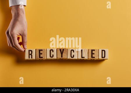 parola riciclata scritta su un blocco di legno. riciclare il testo su una tabella di cemento per il proprio concetto di progettazione Foto Stock