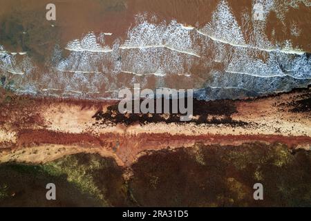 Una vista aerea dall'alto delle onde che si infrangono lungo Cable Head West Beach, Prince Edward Island, Canada Foto Stock