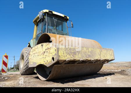 Compattatore per terreno, rullo stradale a tamburo singolo nel cantiere di un'autostrada. Foto Stock