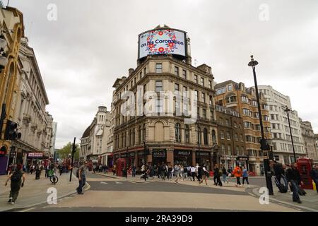 Settimana dell'incoronazione di re Carlo III, Piccadilly Circus mostra i cartelli delle congratulazioni sulla trafficata strada di Londra con i famosi taxi neri e persone. Foto Stock