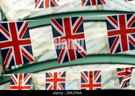 Bandiere inglesi appese a Covent Garden, un popolare mercato all'aperto di Londra con negozi, ristoranti e bar. Primo piano delle bandiere Union Jack che si fanno bunting, che volano. Foto Stock