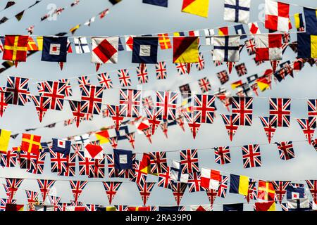 Le bandiere Union Jack del Regno Unito e le bandiere dei segnali navali del Regno Unito decorano lo skyline di un bar a Greenwich, Londra. Le bandiere patriottiche sono uno sfondo perfetto. Foto Stock