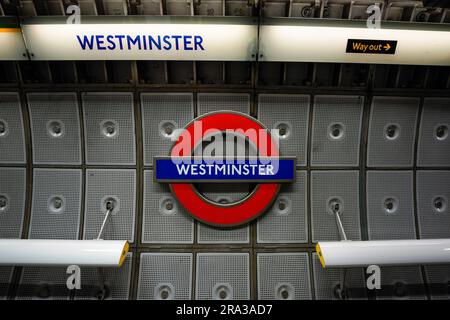 L'iconica insegna della metropolitana di Londra alla stazione di Westminster mostra anche la via d'uscita. La metropolitana di Londra è perfetta per turisti e pendolari. Foto Stock