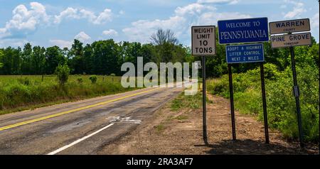 Segnali stradali e un cartello Welcome to Pennsylvania su Akerley Road a Pine Grove Township, Pennsylvania, USA in una soleggiata giornata estiva Foto Stock